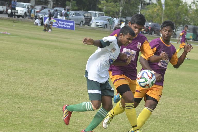 புனித ஹென்றியரசர் அணி வீரர் ஞானேஸ்வரன் அன்தனிராஜைக் கட்டுப்படுத்துவதற்கு திருச்சிலுவை அணியின் இரண்டு வீரர்கள் முயிற்சிக்கும் காட்சி.